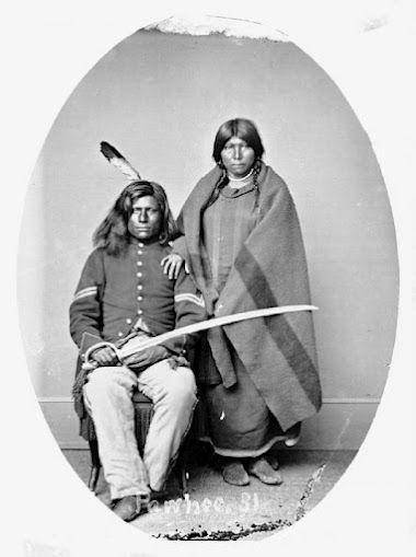 Why does the Pawnee warrior Loots-Tow-Oots hold a sword in the photograph taken of him and his wife