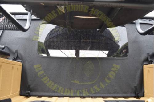 When installing the canvas cargo cover on the HMMWV, what feature holds the canvas top securely agai