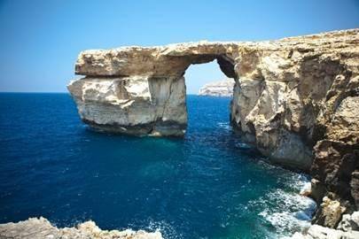 This image shows a sea arch. How did this sea arch most likely form? A. It formed as softer rock bro