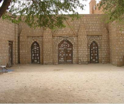 Review the image showing the Sankore mosque in Timbuktu.

How does the architecture of the mosque